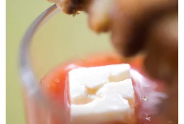 Cube of cheese in tomato soup.
