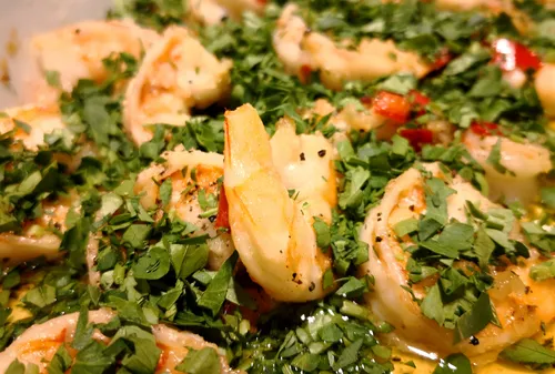 Close-up of shrimp garnished with herbs.