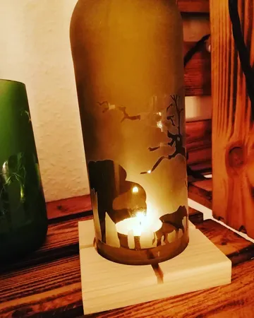 Decorative bottle with candle and elephant silhouette.