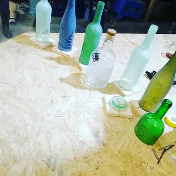 Colored glass bottles on a wooden table indoors.