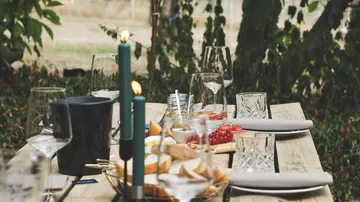 Outdoor table with candles and food.