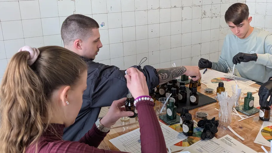 Menschen mischen Düfte an einem Werkstatttisch.