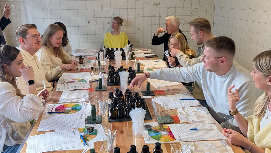 Personen kreieren Parfüms bei einem Tisch-Workshop.
