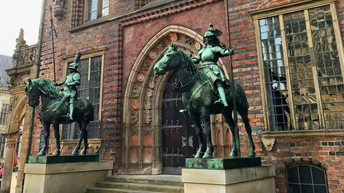 Zwei Reiterstatuen vor historischem Gebäude.