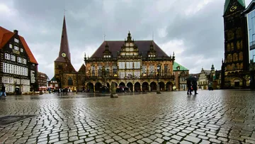 Cobblestone square with historic buildings on a cloudy day.