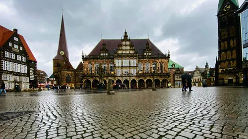 Cobblestone square with historic buildings on a cloudy day.