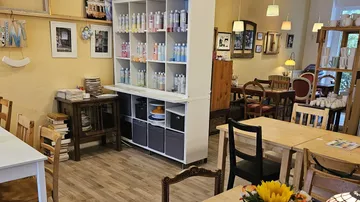 Art studio with tables and shelves of paints.
