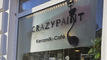 Caféfenster mit CrazyPaint-Logo.