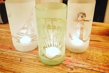 Drei Glaswindlichter mit nautischen Motiven.