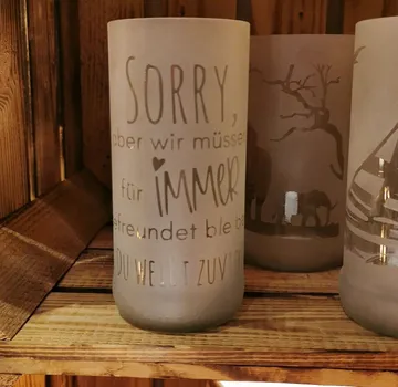 Decorative candle holders on a wooden shelf.