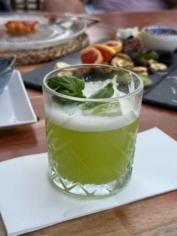 Green cocktail with basil in a glass.