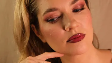 Woman with glamorous makeup, thoughtful expression.
