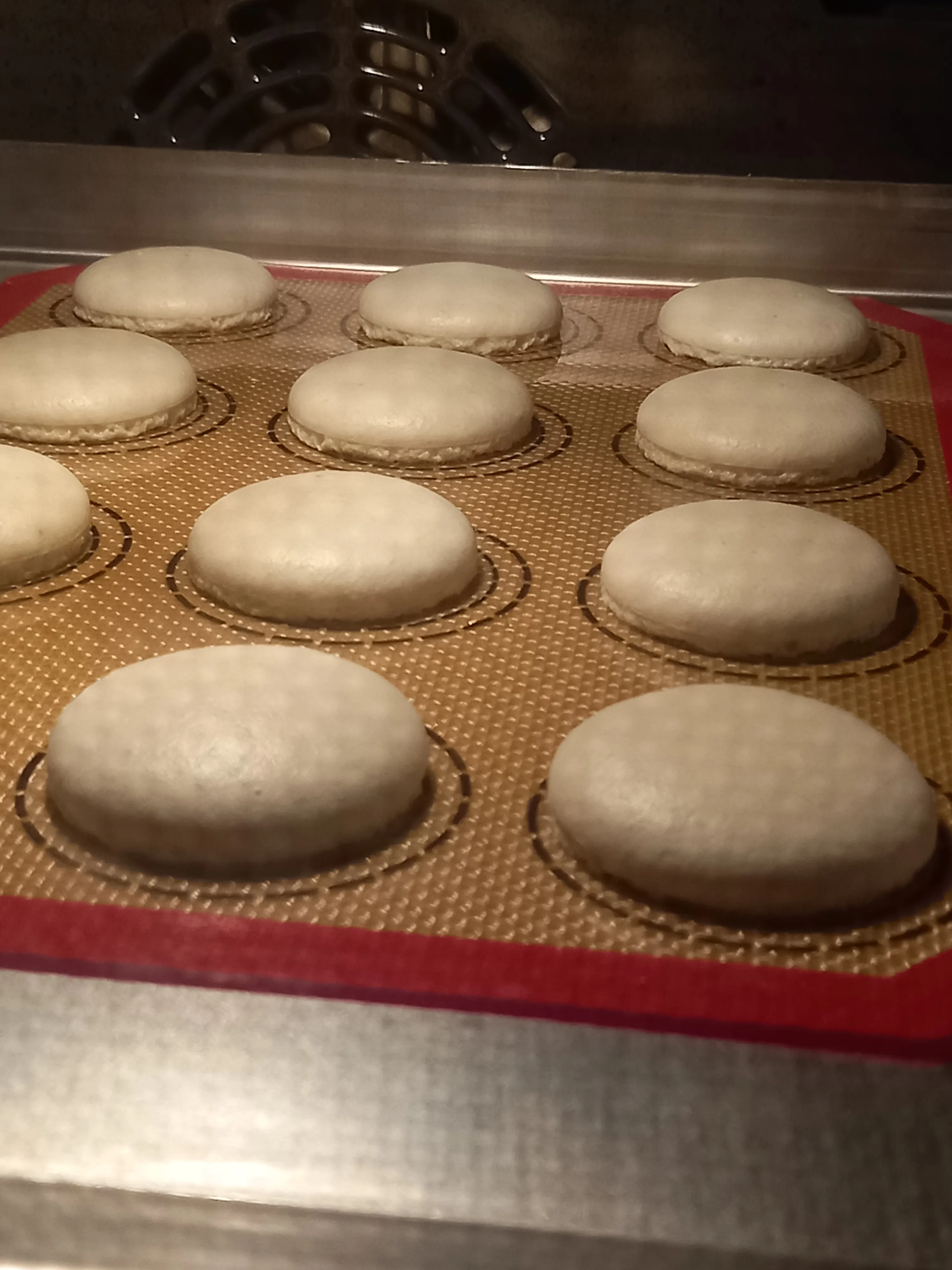 Macaron shells baking on silicone mat.