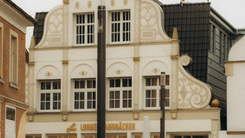 Verziertes weißes Gebäude mit Bäckereischild.