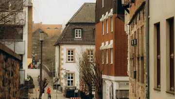 Person geht in einer engen Altstadtstraße.