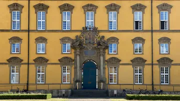 Yellow building facade with many windows.