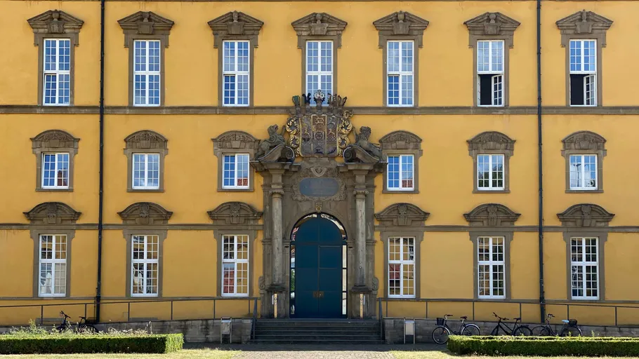 Gelbe Gebäudefassade mit vielen Fenstern.