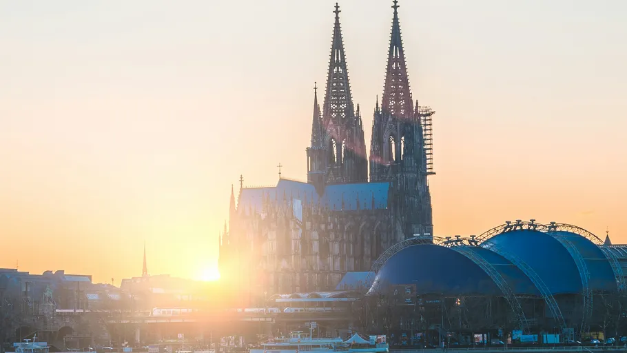 Kölner Dom mit Sonnenuntergang im Hintergrund.