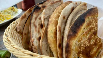 Korb mit gebackenen Fladenbroten mit Sesamkörnern.