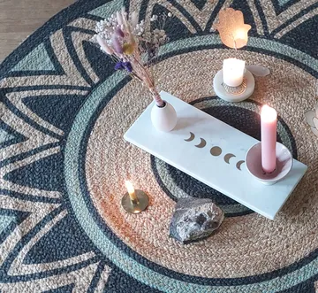 Decorative setup with candles on patterned rug.