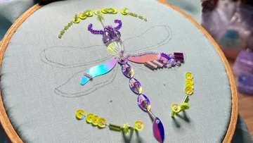 Dragonfly beaded embroidery on fabric hoop.