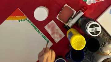 Person malt auf Leinwand mit Kunstbedarf.