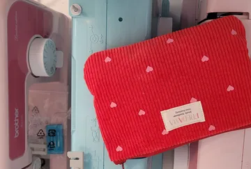 Rote Tasche mit Herzen auf Nähmaschine.