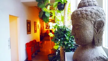 Buddha-Statue im Flur mit Pflanzen.