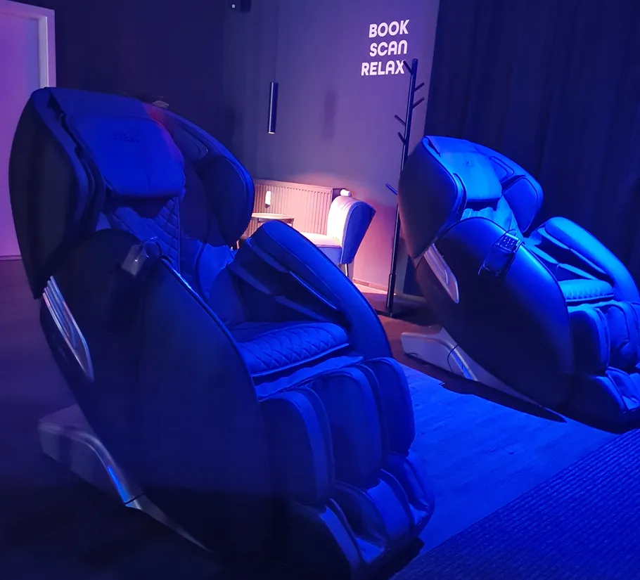Massagesessel in schwach beleuchtetem Entspannungsraum.