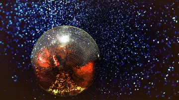Discokugel reflektiert Licht im dunklen Raum.