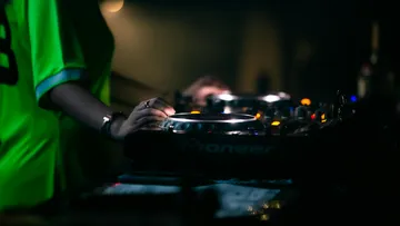DJ bedient Ausrüstung in dunklem Club.