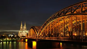 Illuminated bridge and cathedral at night.