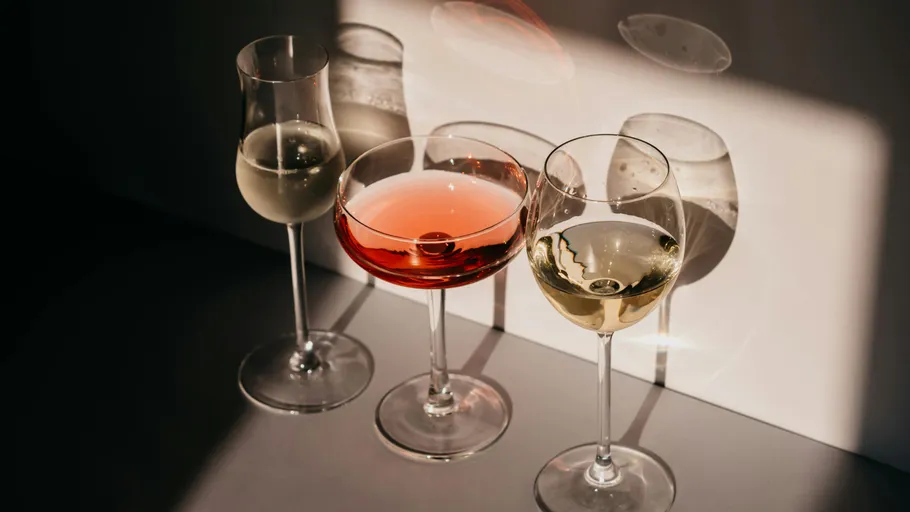 Three glasses casting shadows on surface.