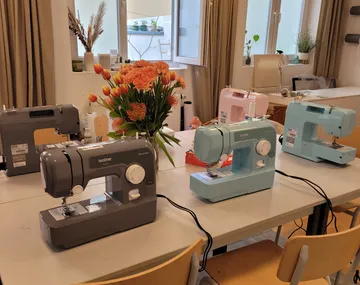 Nähmaschinen auf einem Tisch mit Blumen.