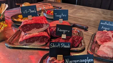 Various meats displayed with labels on table.