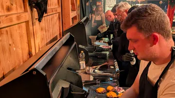 Menschen grillen drinnen in einer Küche.