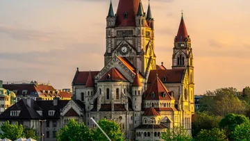 Große Kirche mit roten Dächern bei Sonnenuntergang.
