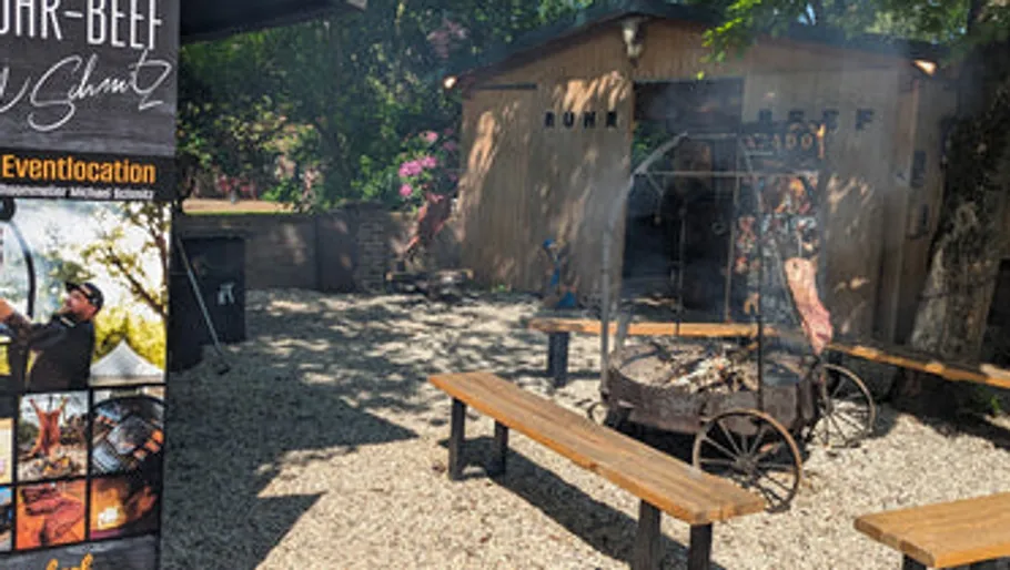 Outdoor grill scene with benches and sign.