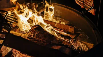 Logs burning in a metal fire pit.