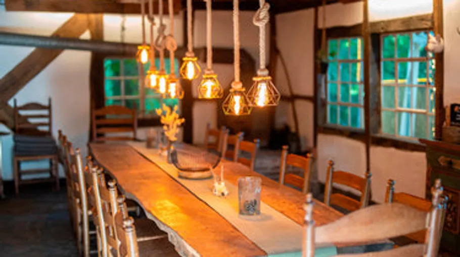 Rustic dining table with hanging lights.