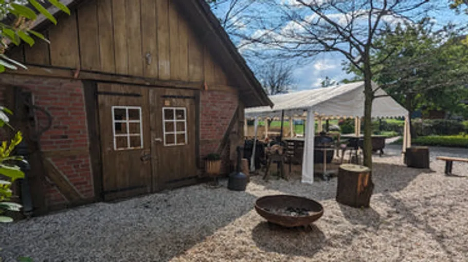Wooden barn, outdoor seating, sunny weather.