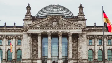 Reichstagsgebäude mit Glaskuppel und Flaggen.