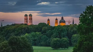 Kirchtürme über Bäumen bei Sonnenuntergang.