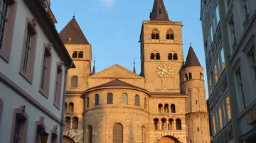 Cathedral towers in sunset light between buildings.