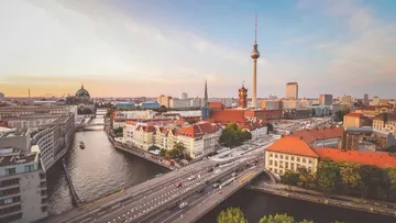 Stadtansicht mit Fluss, Gebäuden und Fernsehturm.