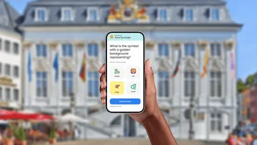 Hand hält Handy mit Quiz in Stadt.