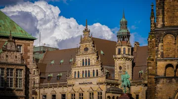 Historische Gebäude mit verzierter Architektur unter Wolkenhimmel.