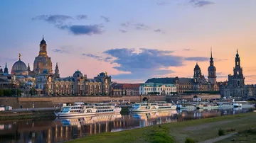 Flussboote vor Dresdner Skyline bei Sonnenuntergang.