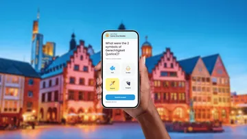 Hand holding phone displaying quiz; city background.