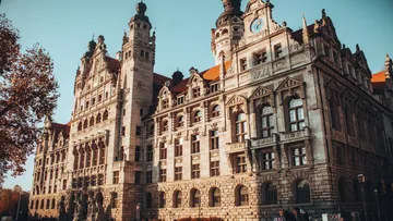 Historisches Gebäude mit Uhrenturm, Herbstbäume.
